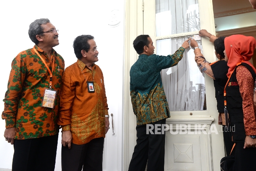 Presiden Joko Widodo menyaksikan petugas BPS menempel sticker tanda sudah dilakukan sensus ekonomi di Istana Merdeka, Jakarta, Rabu (25/5).  (Republika/ Wihdan)