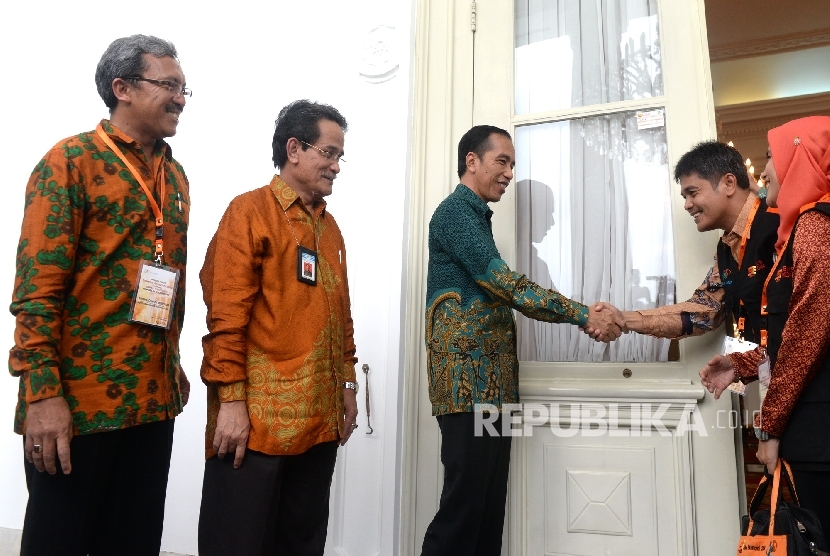 Presiden Joko Widodo menyalami petugas BPS usai menempel sticker tanda sudah dilakukan sensus ekonomi di Istana Merdeka, Jakarta, Rabu (25/5).  (Republika/ Wihdan)