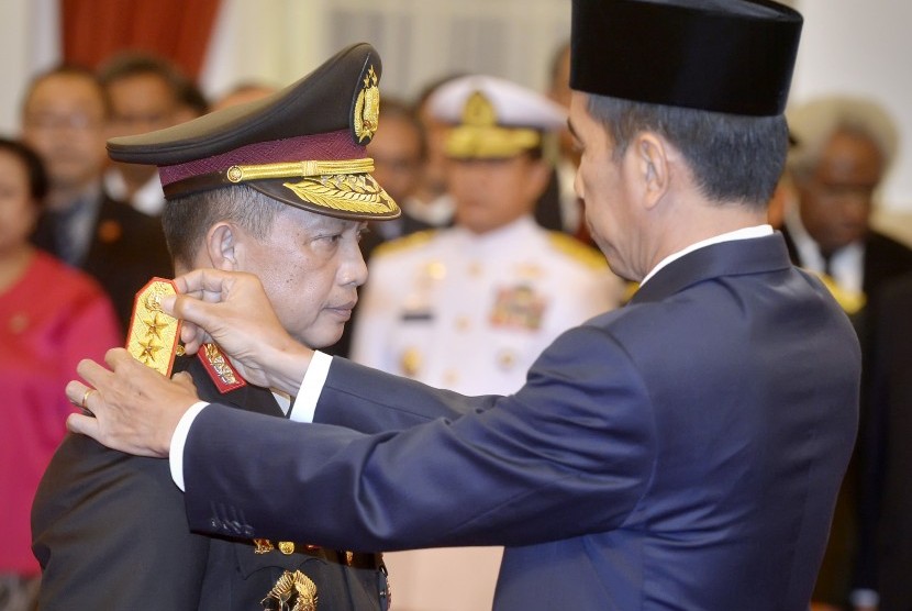 Presiden Joko Widodo menyematkan tanda pangkat bintang empat kepada Kepala Kepolisian Republik Indonesia (Kapolri) Jenderal Polisi Tito Karnavian (kiri) saat acara pelantikan di Istana Negara, Jakarta, Rabu (13/7).  (Antara/Yudhi Mahatma)