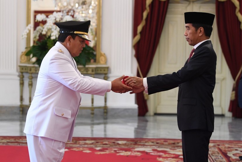 Presiden Joko Widodo menyerahkan petikan keputusan kepada Gubernur Lampung terpilih Arinal Djunaidi sebelum prosesi pelantikan di Istana Merdeka, Jakarta, Rabu (12/6/2019). 