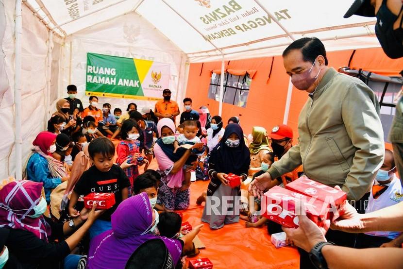 Presiden Joko Widodo saat meninjau posko pengungsian masyarakat yang terdampak erupsi Gunung Semeru, Lumajang, Selasa (7/12). 