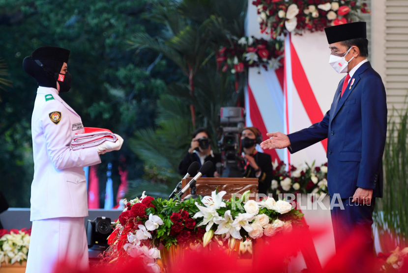 Presiden Joko Widodo selaku inspektur upacara mempersilakan anggota Pasukan Pengibar Bendera Pusaka menaruh bendera Merah Putih saat upacara Penurunan Bendera Merah Putih dalam rangka HUT ke-76 Kemerdekaan RI di Istana Merdeka, Jakarta, Selasa (17/8/2021). 