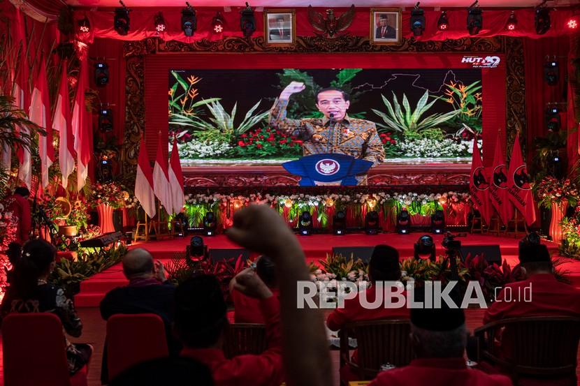 Presiden Joko Widodo tampil di layar saat menyampaikan sambutan dalam peringatan HUT Ke-49 PDIP di kantor DPP PDIP, Jakarta Pusat, Senin (10/1/2022). Berdasarkan survei terbaru Median, efek Jokowi sangat besar terhadap tingginya elektabilitas PDIP.