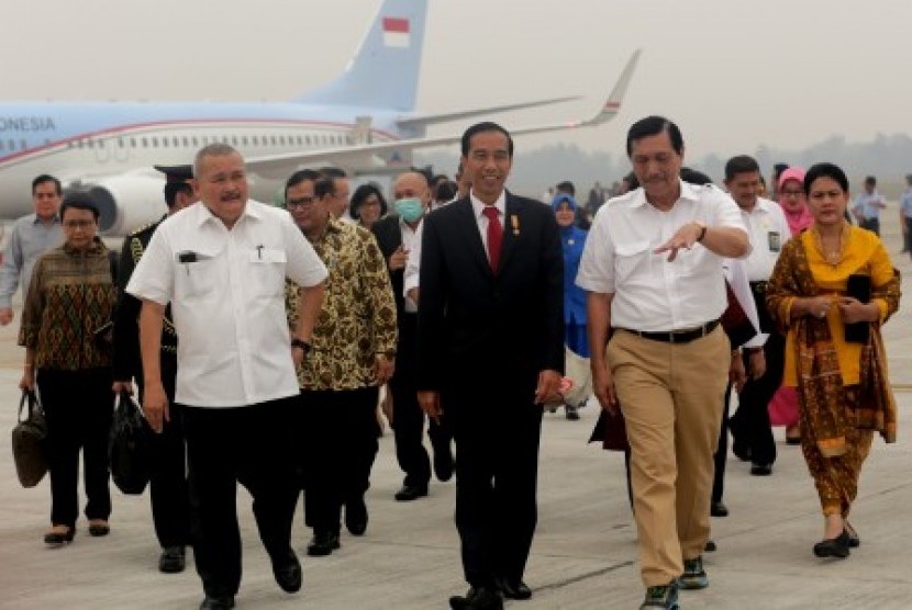 Presiden Joko Widodo (tengah) berbincang dengan Menkopolhukam Luhut Pandjaitan (dua kanan) dan Gubernur Sumatra Selatan saat menuju VIP Bandara Sultan Mahmud (SMB) II, Palembang, Sumsel, Kamis (29/10). 