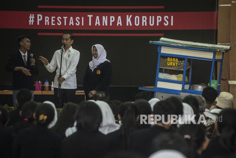 Presiden Joko Widodo (tengah) berbincang dengan murid seusai menyaksikan drama bertajuk Prestasi Tanpa Korupsi di SMKN 57 Jakarta, Jakarta Selatan, Senin (9/12/2019).
