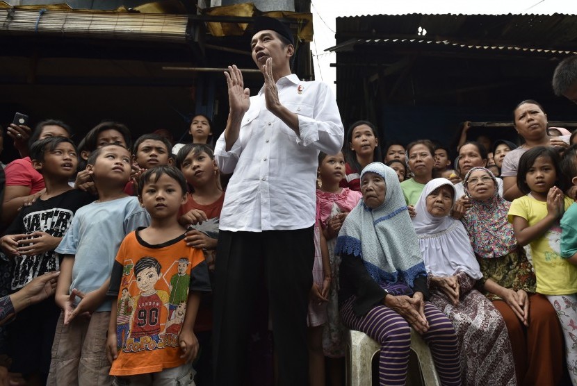 President Joko Widodo (central) was talking to residents after giving basic necessities parcel at Duri Kepa, Jakarta, Thursday (June 22).