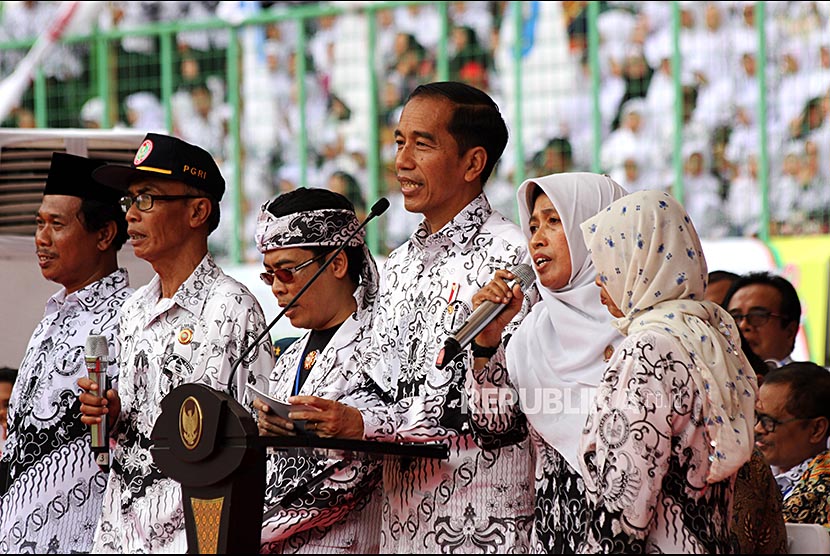 Presiden Joko Widodo (tengah) berdialog dengan sejumlah guru saat menghadiri acara puncak peringatan Hari Guru Nasional di Stadion Patriot Candrabhaga, Bekasi, Jawa Barat, Sabtu (2/12).