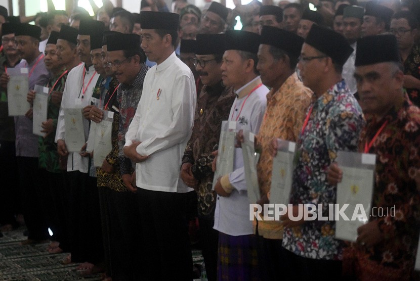 Presiden Joko Widodo (tengah) berfoto bersama para perwakilan penerima sertifikat tanah wakaf usai pembagian di Masjid Baiturrahman, Ngawi, Jawa Timur, Jumat (1/2/2019). 