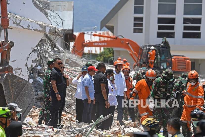 Presiden Joko Widodo (tengah, berhelm) didampingi sejumlah menteri Kabinet Kerja mengawasi proses evakuasi korban gempa di reruntuhan Hotel Roaroa di Palu, Sulawesi Tengah, Rabu (3/10).