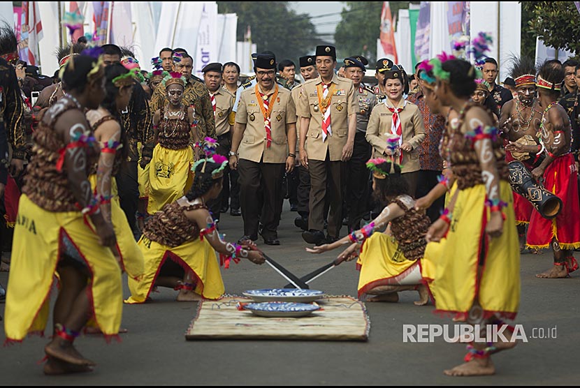 Presiden Joko Widodo (tengah) berjalan bersama Ibu Negara Iriana Joko Widodo (kanan) dan  Ketua Kwartir Nasional Gerakan Pramuka Adhyaksa Dault (kiri) mengikuti prosesi Raimuna Nasional XI 