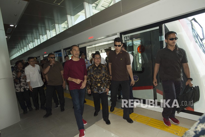 Presiden Joko Widodo (tengah) berjalan bersama tamu undangan Muhaimin Iskandar turun dari Skytrain sebelum peresmian pengoperasian kereta bandara di Bandara Soekarno-Hatta, Tangerang, Banten (2/1). 