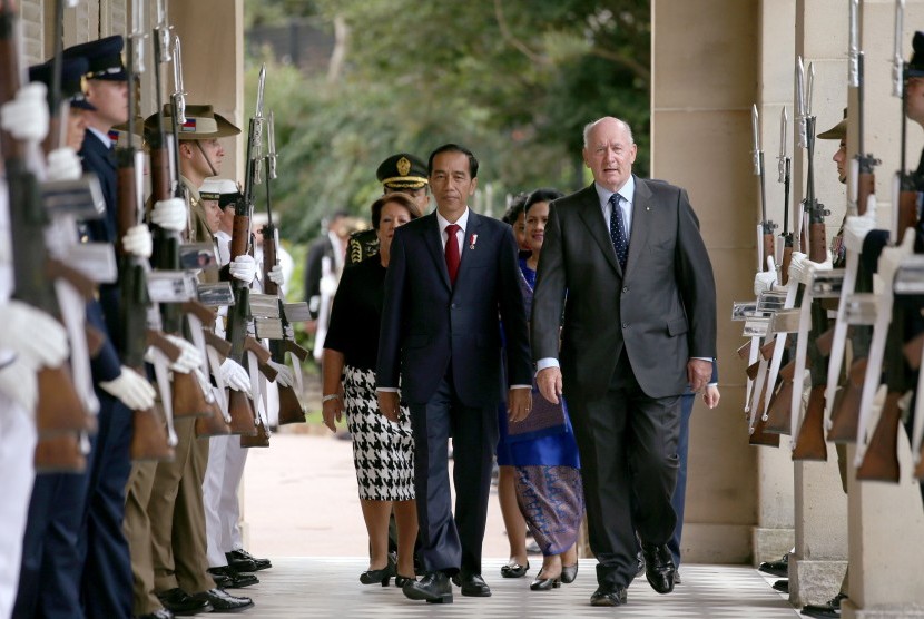 Presiden Joko Widodo (tengah) berjalan melewati barisan pasukan kehormatan didampingi Gubernur Jenderal Australia Peter Cosgrove (kanan) saat tiba di Admiralty House di Sydney, Australia, Minggu (26/2). 