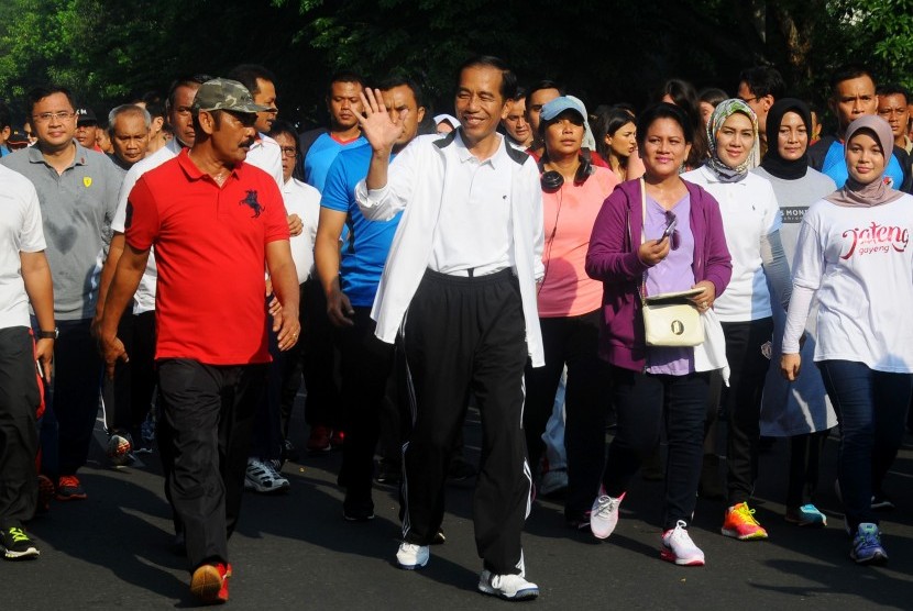 Presiden Joko Widodo (tengah) bersama Ibu Negara Iriana (keempat kanan), dan Wali Kota Surakarta FX Hadi Rudyatmo (kedua kiri) melakukan jalan santai pada hari bebas kendaraan di Solo, Jawa Tengah, Minggu (16/10). 