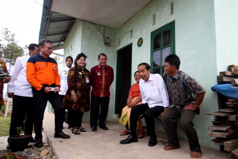 Presiden Joko Widodo (tengah) bersama Kepala BNPB Willem Rampangilei (kiri) dan Bupati Karo Terkelin Brahmana (kiri ketiga) berbincang dengan warga saat berkunjung di kawasan perumahan relokasi pengungsi Gunung Sinabung di Desa Siosar, Karo, Sumatra Utara, Sabtu (14/10). 