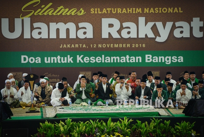  Presiden Joko Widodo (tengah) bersama Ketua Umum Partai Kebangkitan Bangsa (PKB) Muhaimin Iskandar (kelima kiri) dan para ulama berdoa bersama saat menghadiri Silaturahmi Nasional Ulama Rakyat di Jakarta, Sabtu (12/11).