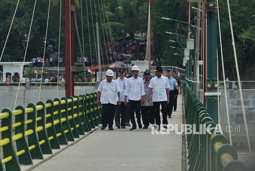 Presiden Joko Widodo (tengah) bersama Menteri PUPR Basuki Hadimuljono (kiri) dan Gubernur DIY Sri Sultan HB X (kanan) melintasi Jembatan Bendung Kamijoro saat peresmian di Kulonprogo, D.I Yogyakarta, Selasa (31/12/2019).