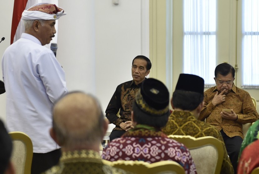 Presiden Joko Widodo (tengah) bersama Wakil Presiden Jusuf Kalla (kanan) mendengarkan laporan Ketua Umum Asosiasi Forum Kerukunan Umat Beragama Ida Penglingsir Agung Putra Sukahet (kiri) saat pertemuan di Istana Bogor, Jawa Barat, Selasa (23/5).