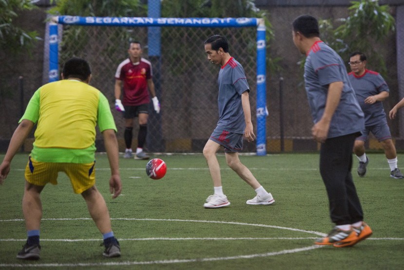 Presiden Joko Widodo (tengah) berusaha mengontrol bola saat bermain futsal di Lapangan Futsal Time, Kelapa Gading, Jakarta, Selasa (7/2). 