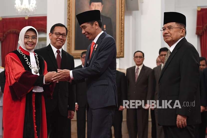 Presiden Joko Widodo (tengah) dan Wakil Presiden Jusuf Kalla (kanan) memberi ucapan selamat kepada Hakim Mahkamah Konstitusi Enny Nurbaningsih (kiri) seusai pelantikan di Istana Negara, Jakarta, Senin (13/8). 