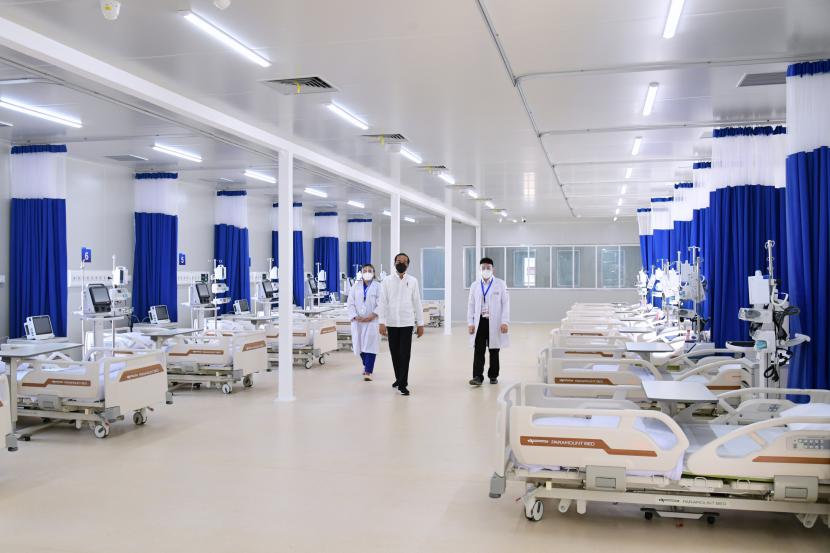 Presiden Joko Widodo (tengah) didampingi dua orang tenaga kesehatan meninjau sejumlah fasilitas usai meresmikan Rumah Sakit Modular Pertamina di Jakarta.