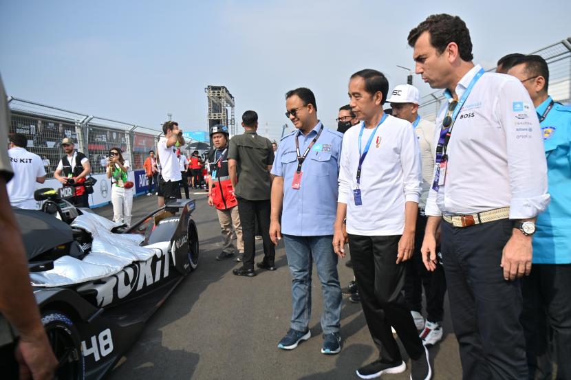 Presiden Joko Widodo (tengah) didampingi Gubernur DKI Jakarta Anies Baswedan (kiri) dan Chief Formula E Alberto Longo (kanan) melihat mobil balap listrik di grid line sebelum dimulainya balapan Formula E Jakarta di Jakarta International E-Prix Circuit (JEIC) Ancol, Jakarta, Sabtu (4/6/2022).