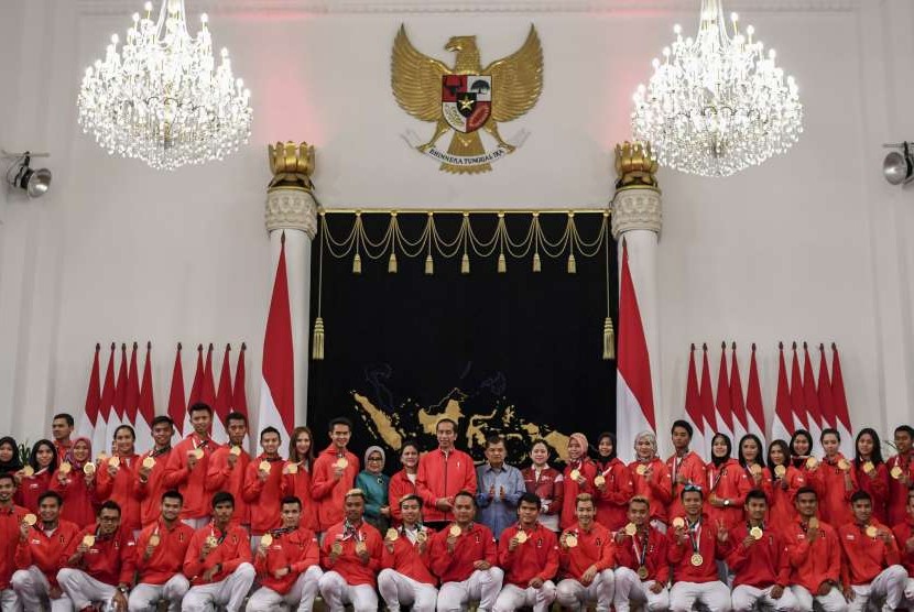 Presiden Joko Widodo (tengah) didampingi Ibu Negara Iriana Joko Widodo (kedua belas kiri), Wakil Presiden Jusuf Kalla (ketiga belas kanan), Ibu Mufidah Jusuf Kalla (sebelas kiri) dan Menko PMK Puan Maharani (kedua belas kanan) berfoto bersama atlet peraih medali saat pemberian bonus di Istana Negara, Jakarta, Minggu (2/9).