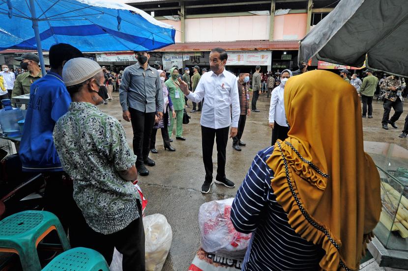 Presiden Joko Widodo (tengah) didampingi Ibu Negara Iriana Joko Widodo (kanan) berbincang dengan sejumlah pedagang makanan saat kunjungan kerja ke Pasar Modern Angso Duo di Jambi, Kamis (7/4/2022). Tingkat kepuasan publik terhadap Jokowi belakangan mengalami tren penurunan berdasarkan beberapa hasil survei. (ilustrasi)