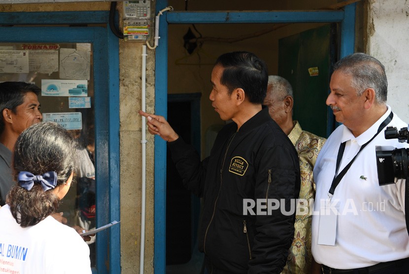  President Joko Widodo (center) accompanied by BUMN Minister Rini Soemarno (left) and PLN Managing Director Sofyan Basir (right) turns on electricity when reviewing the connection of free electricity installations made available through the synergy of BUMN for the community in Bantarjati, Bogor, West Java, Sunday (Dec 2).