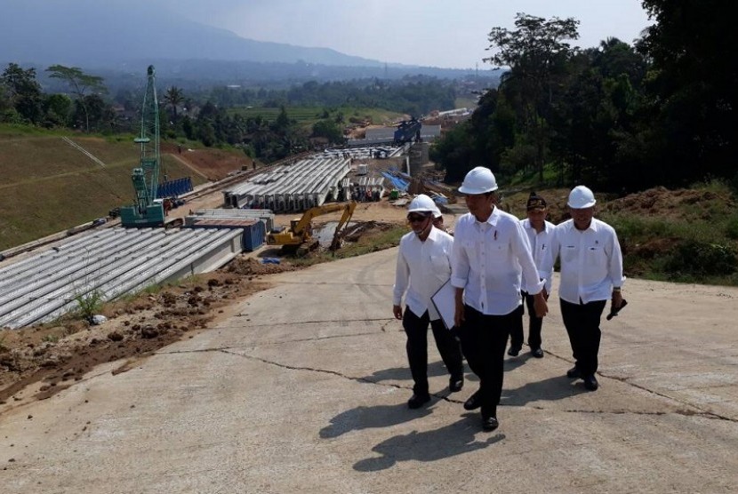 Presiden Joko Widodo (tengah) didampingi Menteri PUPR Basuki Hadimuljono (kanan) meninjau pembangunan jalan tol Bocimi seksi satu, Rabu (21/6).