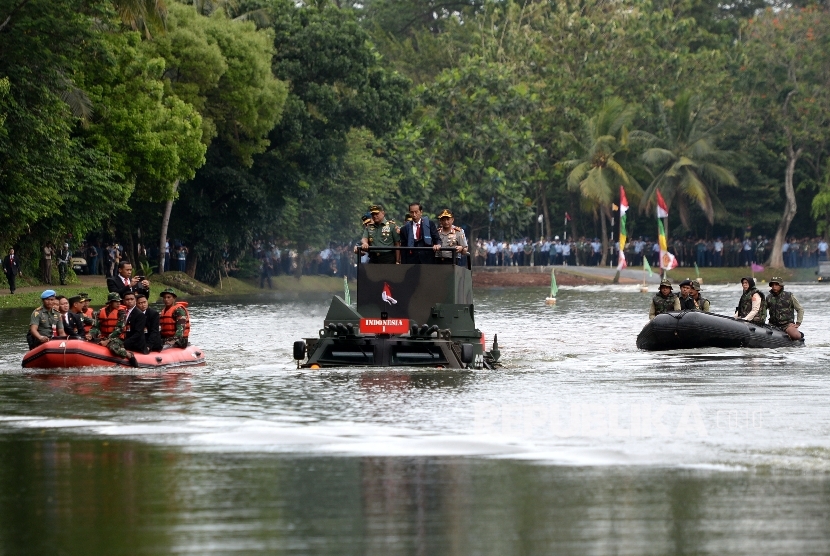 Presiden Joko Widodo (tengah) didampingi Panglima TNI Gatot Nurmantyo (kiri) dan Kapolri Tito Karnavian menyusuri danau menggunakan Panser Anoa 2 6x6 Amphibious sebelum Rapat Pimpinan TNI di Mabes TNI, Cilangkap, Jakarta, Senin (16/1). 