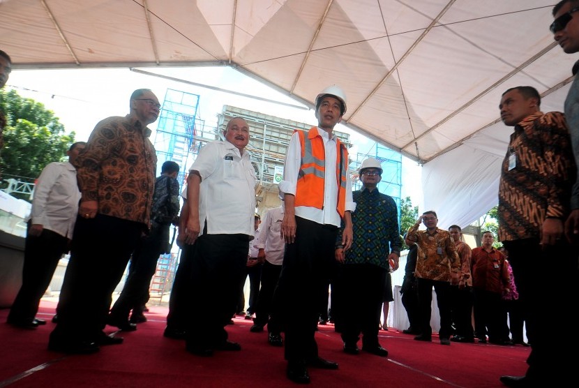 Presiden Joko Widodo (tengah) didampingi Sekretaris Kabinet Pramono Anung (kanan), dan Gubernur Sumatera Selatan Alex Noerdin (kedua kiri) menyapa wartawan saat kunjungan kerja di Sultan Mahmud Badaruddin II Palembang, Sumsel, Kamis (3/3).