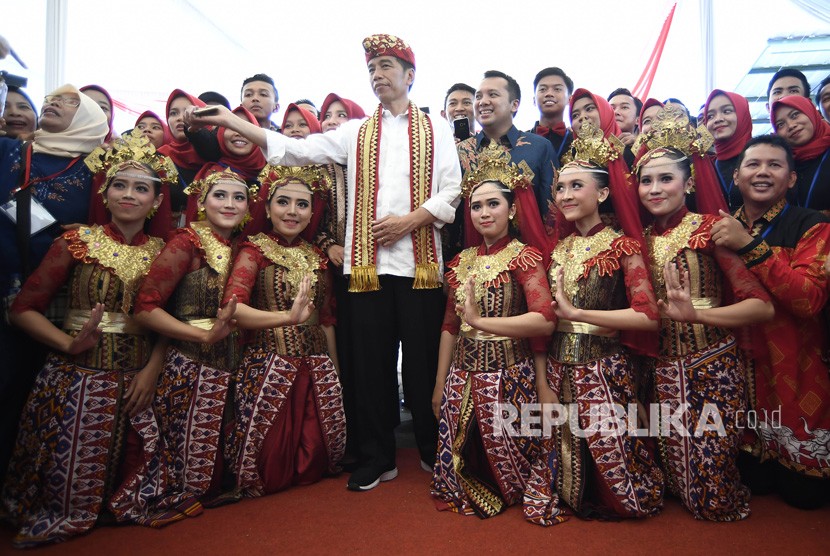 Presiden Joko Widodo (tengah) melayani permintaan foto bersama warga usai membagikan Sertifikat Tanah untuk Rakyat di Lapangan Tenis Indoor Pemda Lampung Tengah, Lampung, Jumat (23/11/2018).
