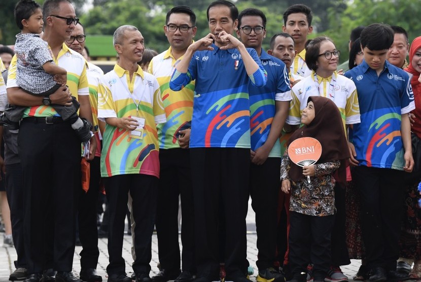 Presiden Joko Widodo (tengah) didampingi Ketua PPDI Gufroni Sakaril saat menghadiri Peringatan Hari Disabilitas Internasional Tahun 2018 di Bekasi, Jawa Barat, Senin (3/12/2018). 