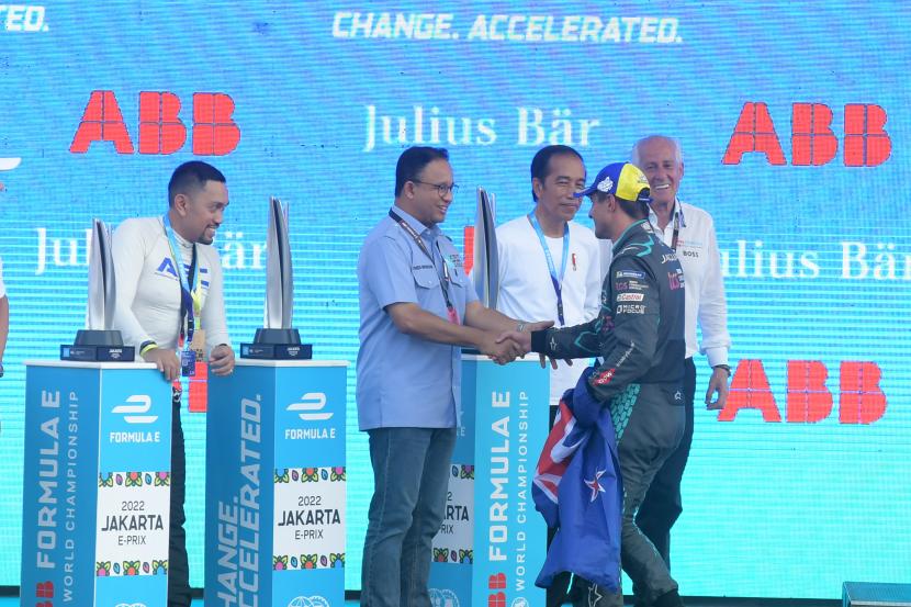 Presiden Joko Widodo (tengah) menyaksikan Gubernur DKI Jakarta Anies Baswedan (kedua kiri) menyalami pembalap Jaguar TCS Mitch Evans (kedua kanan) usai menjuarai balapan Formula E seri kesembilan di Jakarta International E-Prix Circuit (JIEC), Jakarta, Sabtu (4/6/2022).