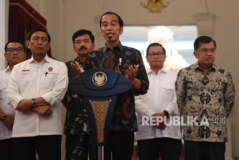 Presiden Joko Widodo (tengah) menyampaikan keterangan terkait kerusuhan pascapengumunan hasil pemilu 2019 di Istana Merdeka, Jakarta, Rabu (22/5/2019). 