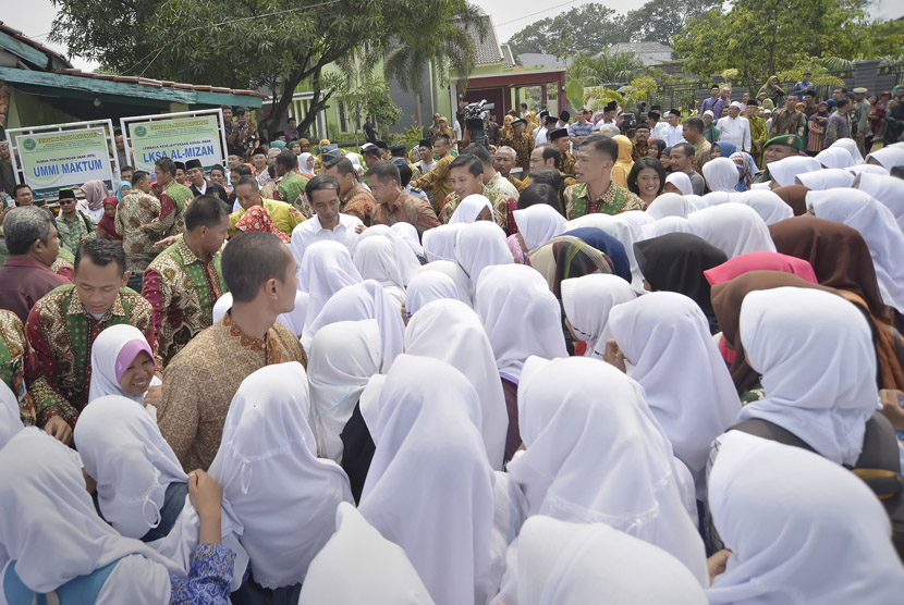 Presiden Joko Widodo (tengah) menyapa santri saat mengunjungi Pondok Pesantren Al Mizan Jatiwangi, Majalengka, Jawa Barat, Kamis (14/1).