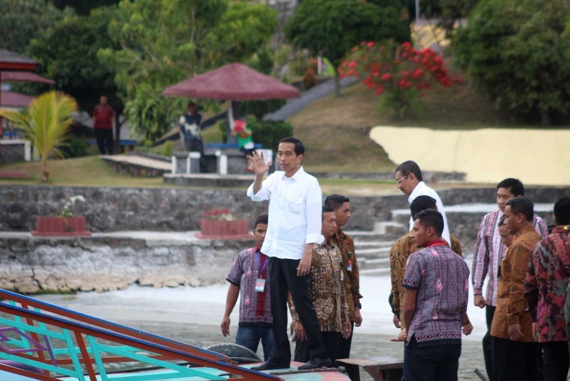 Presiden Joko Widodo (tengah) menyapa warga sebelum menyeberangi Danau Toba untuk berkunjung ke Pulau Samosir di Parapat, Simalungun, Sumatera Utara, Minggu (21/8). 