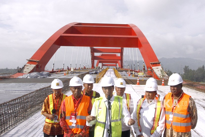 Presiden Joko Widodo (tengan) didampingi Menteri Pekerjaan Umum dan Perumahan Rakyat (PUPR) Basuki Hadimuljono (ketiga kanan) dan sejumlah pejabat daerah setempat memberi keterangan saat meninjau proyek pembangunan Jembatan Holtekamp di Jayapura, Papua, Kamis (12/4). 