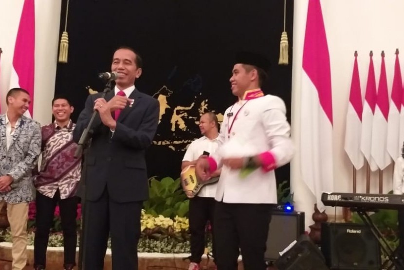 Presiden Jokowi dan anggota paduan suara Gita Bahana Nusantara asal Sulawesi Selatan, Abel Romario P di Istana Negara, Sabtu (17/8). 