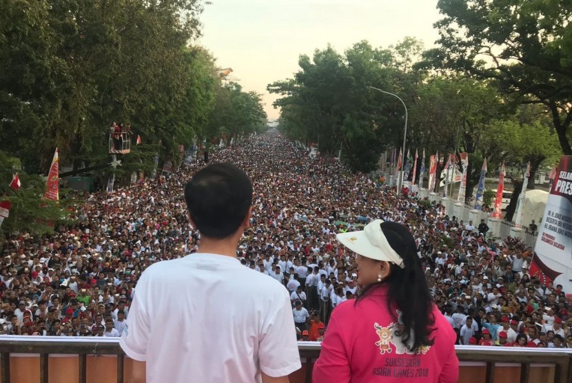 Presiden Jokowi dan Ibu Negara Iriana menyapa peserta jalan sehat yang diprakarsai Sahabat Rakyat Indonesia di Makassar,Sulawesi Selatan, Ahad (29/7) pagi.
