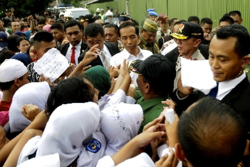 Presiden Jokowi disambut siswa SD di sentra rajut Binong Jati, Bandung, Senin (12/1).