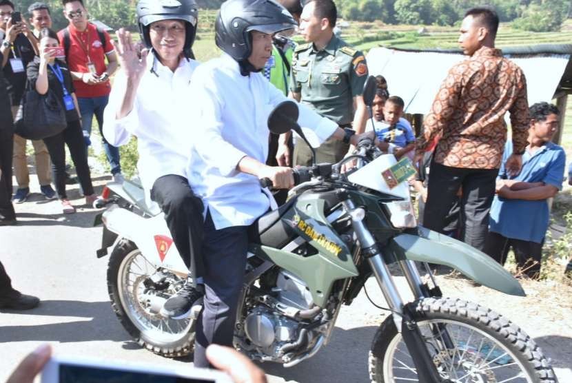 Gubernur NTB TGB Zainul Majdi membonceng Presiden Jokowi saat meninjau pengungsi di Dusun Terengan, Desa Pemenang Timur, Kecamatan Pemenang, Lombok Utara.