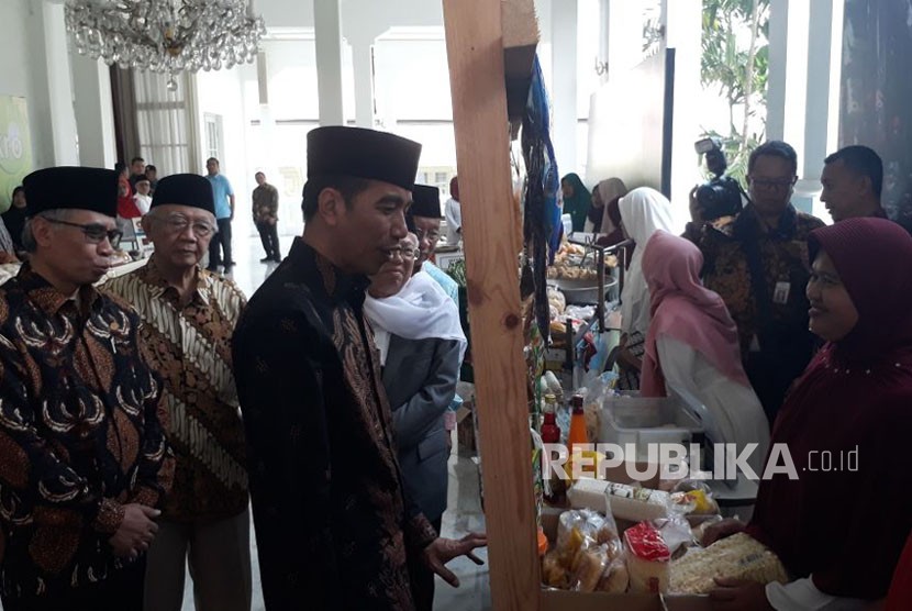 Presiden Jokowi meninjau pameran pedagang yang ikut dalam program bank wakaf mikro di Istana Negara, Rabu (28/3). 