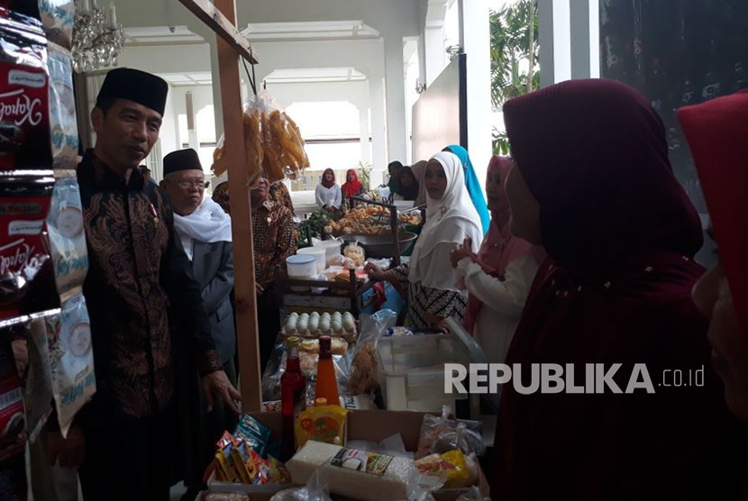 Presiden Jokowi meninjau pameran pedagang yang ikut dalam program bank wakaf mikro di Istana Negara, Rabu (28/3). 
