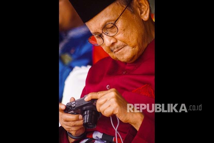 Presiden ke-3 Republik Indonesia B.J. Habibie melihat hasil foto di kamera digitalnya saat menghadiri Peringatan HUT ke-61 Provinsi Riau di Kota Pekanbaru, Kamis (9/8).