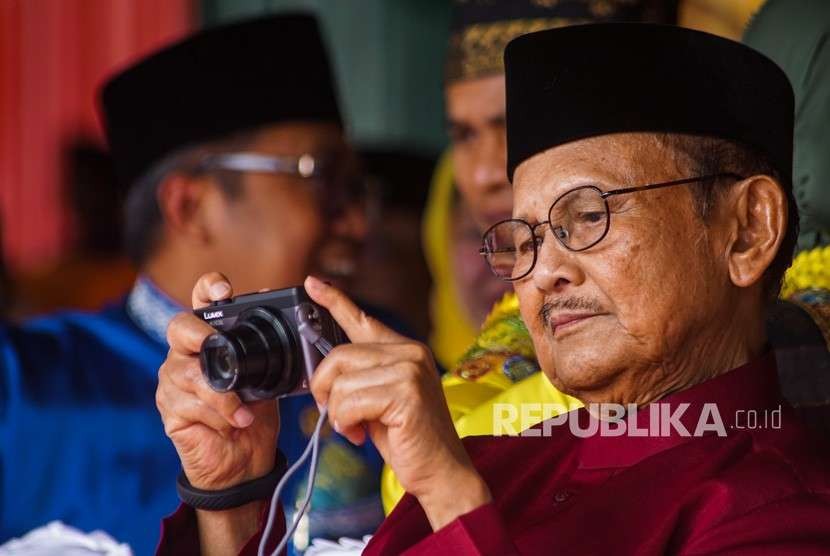 Presiden ke-3 Republik Indonesia B.J. Habibie memotret dengan kamera digital saat menghadiri Peringatan HUT ke-61 Provinsi Riau di Kota Pekanbaru, Kamis (9/8).