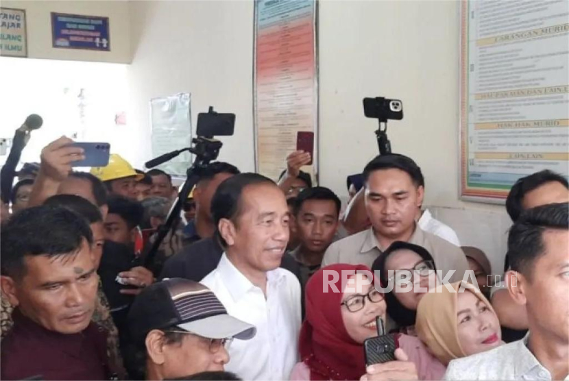 Presiden ke-7 RI Joko Widodo (Jokowi) melayani swafoto dengan warga pada hari pemungutan suara di Solo, Jawa Tengah, Rabu (27/11/2024).