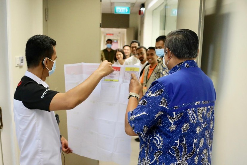 Presiden keenam RI Susilo Bambang Yudhoyono (SBY) ketika memeriksa surat suara yang akan digunakan oleh istrinya, Ani Yudhoyono. Ibu Ani yang sedang menjalani perawatan menggunakan hak pilihnya di National Universitity Hospital Singapura, Ahad (14/4).