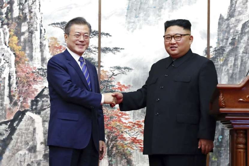 Korsel dan Korut Pulihkan Hotline Kedua Negara. Presiden Korea Selatan Moon Jae-in bersalaman dengan pemimpin tertinggi Korea Utara Kim Jong-un di Pyongyang. 