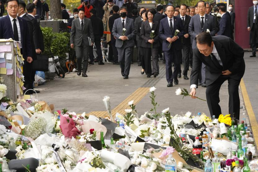 Presiden Korea Selatan Yoon Suk Yeol menempatkan bunga untuk memberi penghormatan kepada korban kecelakaan maut setelah perayaan Halloween Sabtu malam di sebuah jalan dekat tempat kejadian di Seoul, Korea Selatan, Selasa, 1 November 2022.